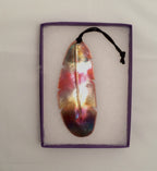 Colorful feather pendant in a purple frame on a light gray background