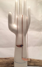 Necklace displayed on a mannequin bust against a white background
