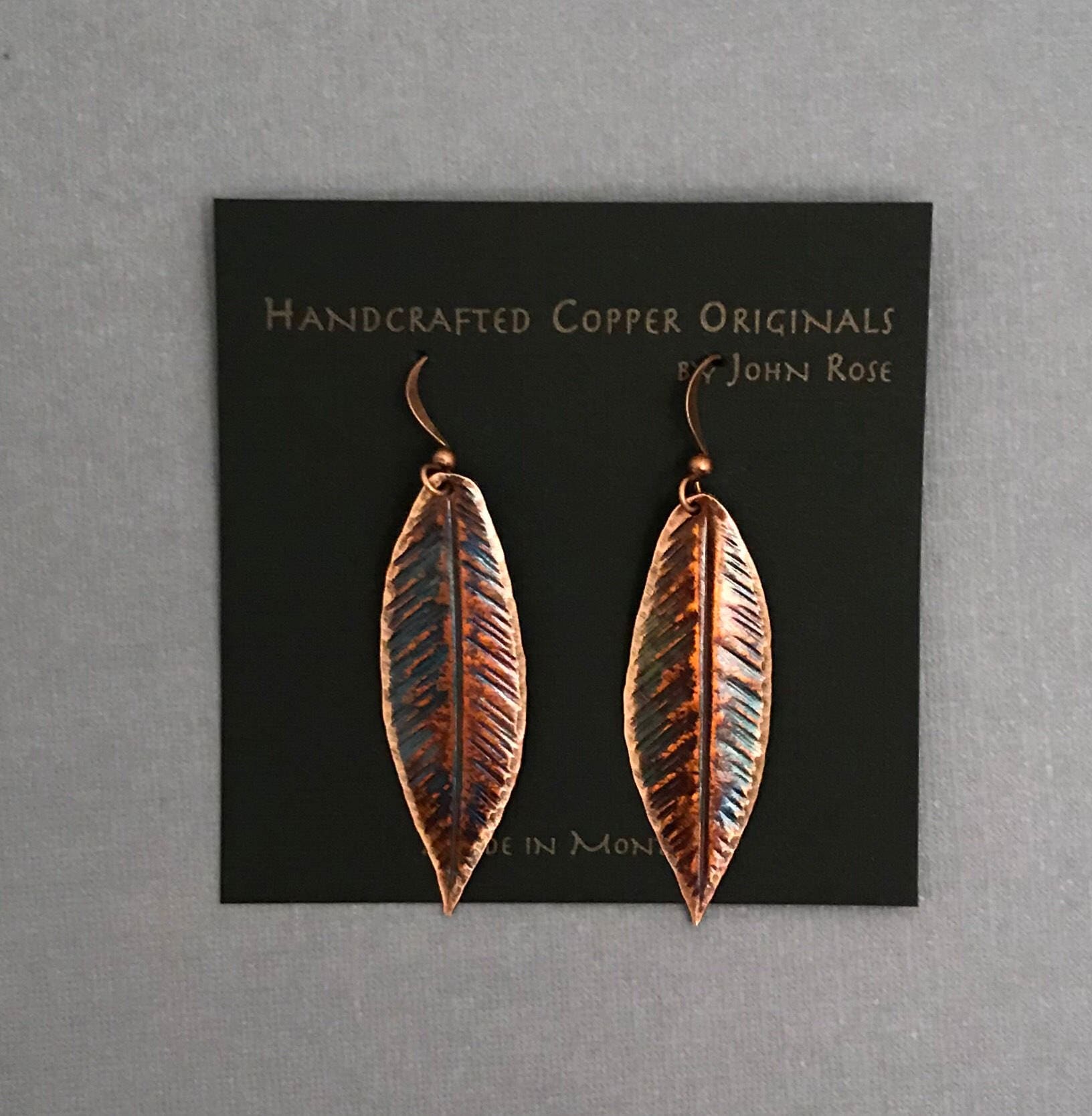 Copper leaf-shaped earrings on a card with 'Handcrafted Copper Originals by John Rose' text.