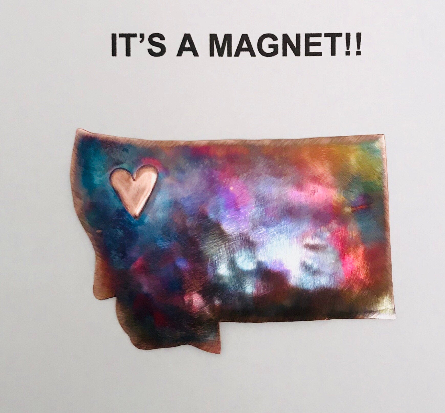Colorful magnet shaped like a state with a heart in the center on a white background.