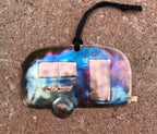 Colorful copper camper ornament with 'EXPLORE' text on a textured surface