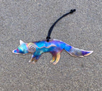 Colorful fox-shaped ornament with a spiral design on a gray surface